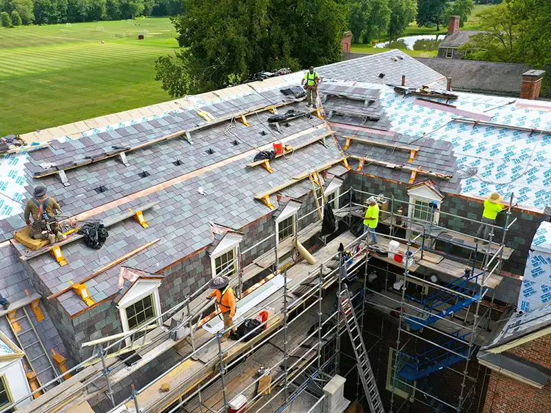 Crew installing new slate tiles on school